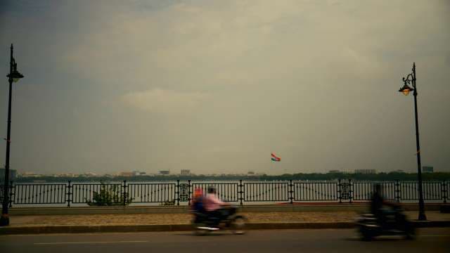 Motorbikes Speeding Past Hussain Sagar Lake in Hyderabad India