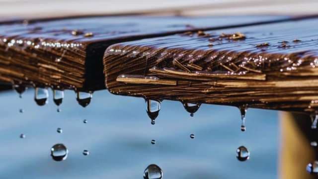 Water Droplets Falling from Wet Wooden Pier