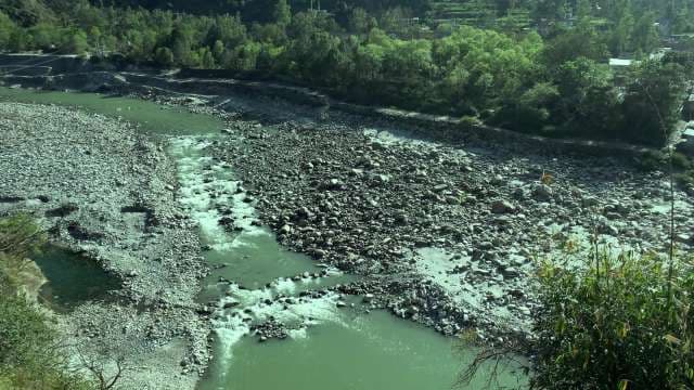 Scenic Rocky River Flowing Through Lush Green Mountain Valley