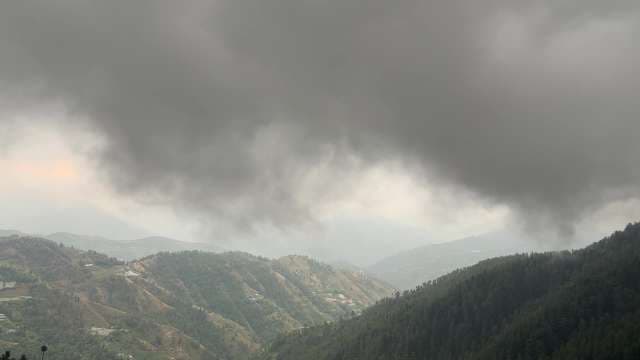 Dark Storm Clouds Over Forested Mountain Range