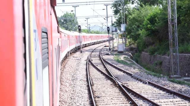 Indian Express Train Navigating Curved Tracks in Rural Landscape