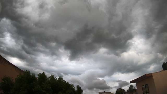 Dramatic Storm Clouds Over Residential Rooftops and Trees