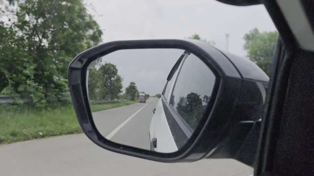 Car Side Mirror Reflection of Highway with Distant Truck