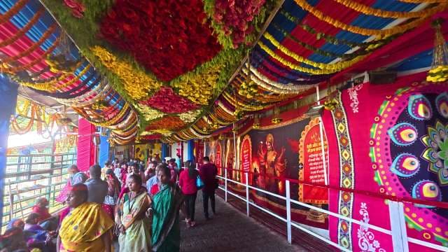 Vibrant Indian Temple Corridor with Devotees and Flower Decorations
