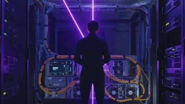 IT Professional in Futuristic Server Room with Purple Neon Lights