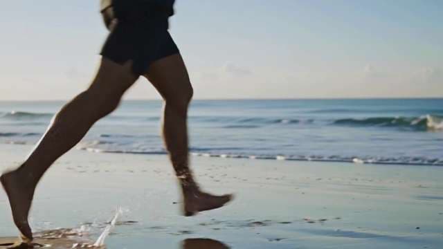 Man Running Barefoot on Tropical Beach Shoreline