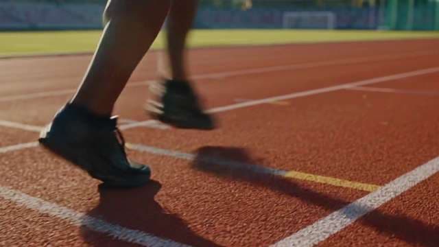 Close Up of Athlete Feet Running on Red Track