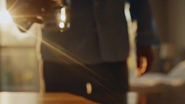 Cinematic Shot of Person Holding Glass with Golden Hour Sun Flare