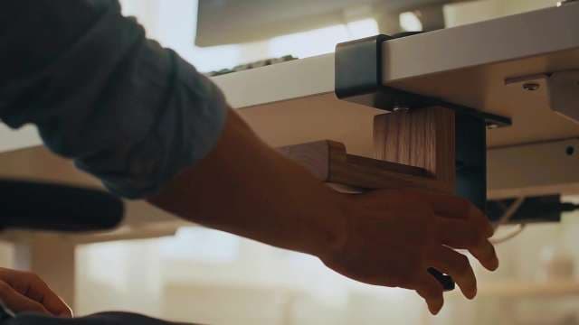 Person Adjusting Wooden Office Desk Accessory
