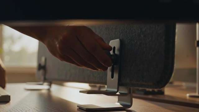 Close-Up of Hand Adjusting Desk Partition Clamp