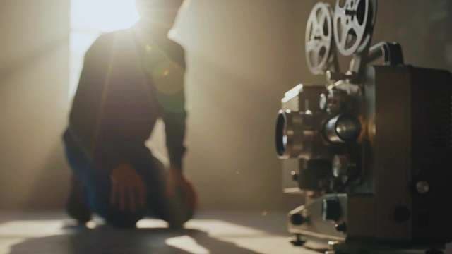 Vintage Film Projector with Cinematic Lens Flare and Silhouette Background