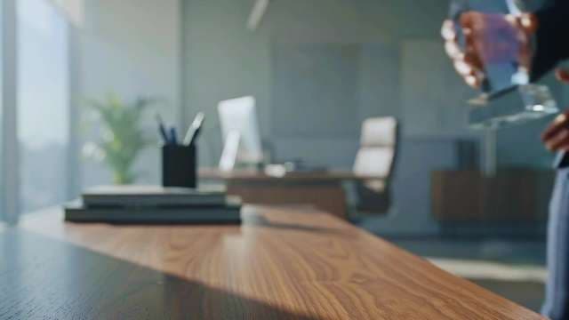 Businessman Holding Crystal Award Trophy in Modern Office