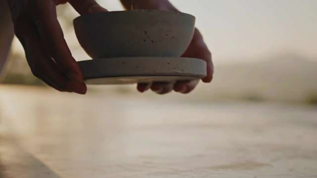 Close-up of Hands Holding Minimalist Ceramic Bowl at Golden Hour