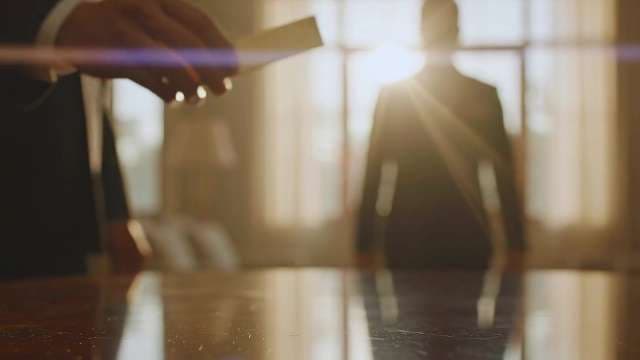 Professional Businessman Exchanging Business Card in Sunlit Corporate Office