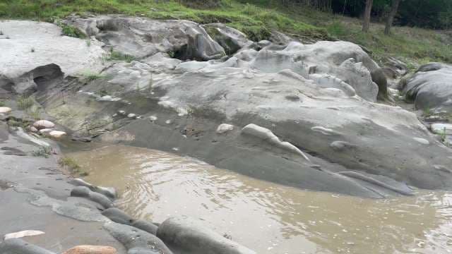Murky Water Flowing Through Unique Smooth Rock Formations