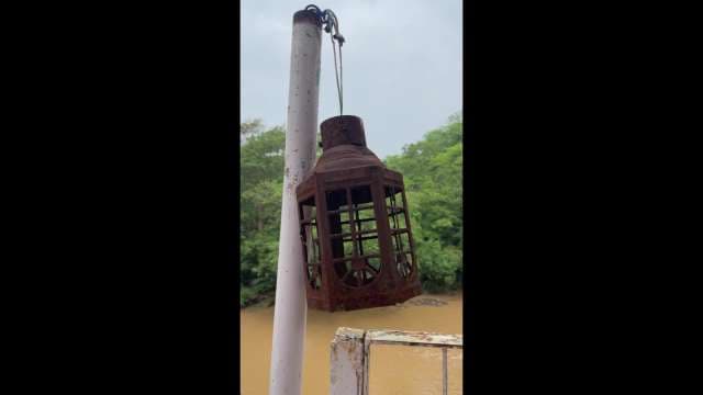 Vintage Rusty Metal Lantern Hanging Near Murky River