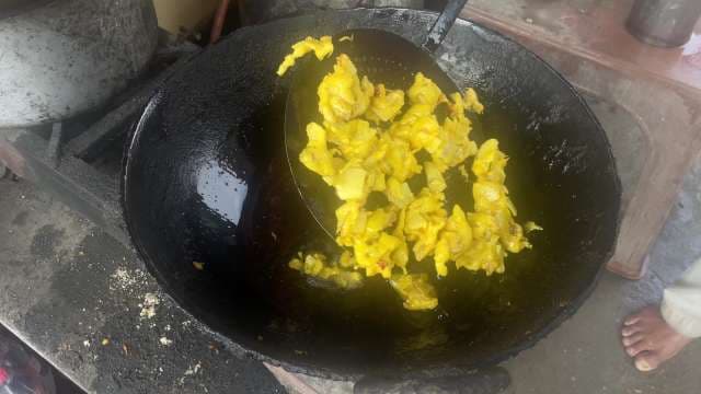 Street Vendor Frying Crispy Yellow Pakoras in Large Iron Wok