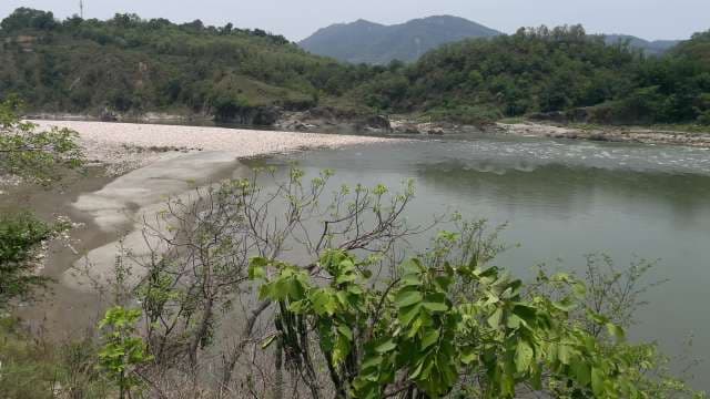 Scenic River Flowing Through Lush Green Hills and Mountains