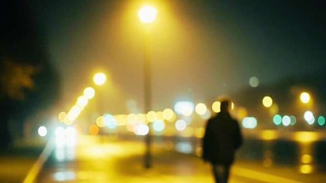 Cinematic Blurry Silhouette Walking Along City Street at Night