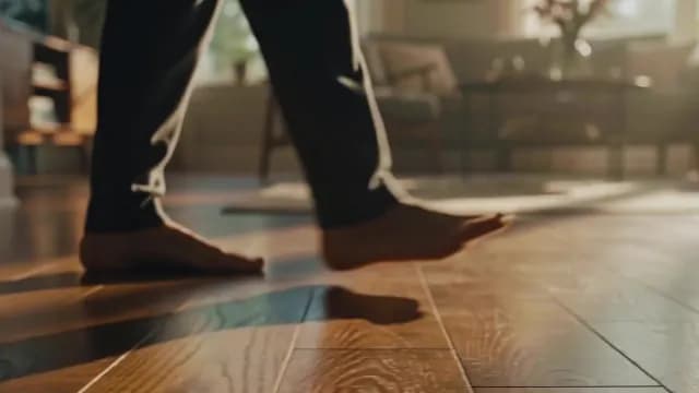 Person Walking Barefoot on Warm Hardwood Floor at Home