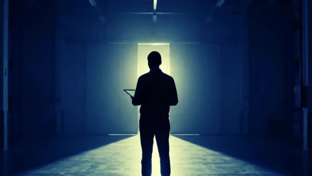 Silhouette of Industrial Engineer with Tablet in Dark Warehouse