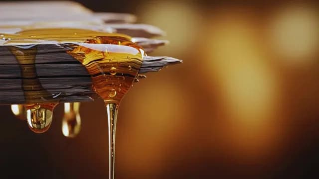 Macro Shot of Golden Honey Dripping from Rustic Wood Surface