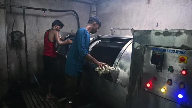 Workers Operating Industrial Washing Machine in Factory