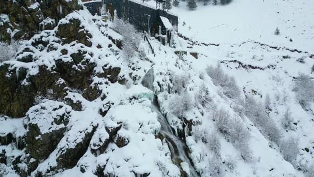 Aerial Winter View of Frozen Mountain Waterfall and Snow-Covered Cliffs in Srinagar
