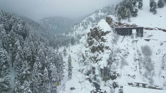 Aerial View of Snowy Mountain Valley with Frozen Waterfall and Forest in Srinagar