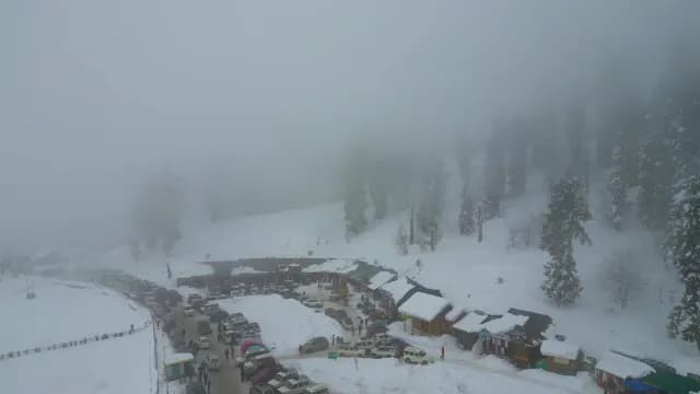 Foggy Aerial View of Snowy Mountain Village and Parking Lot in Srinagar