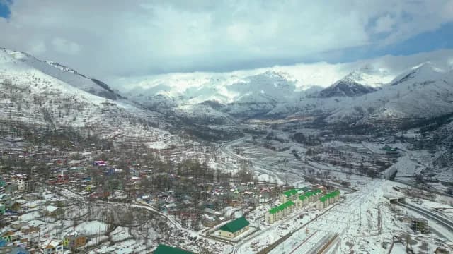 Aerial View of Winter Village in Snowy Kashmir Mountain Valley
