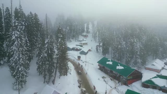 Aerial View of Snowy Gulmarg Village and Foggy Pine Forest