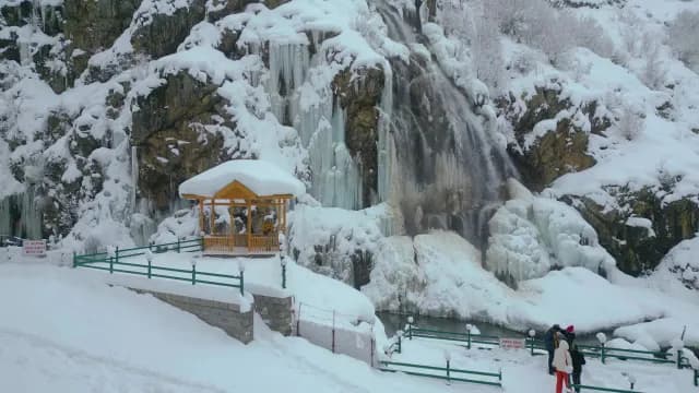 Frozen Waterfall and Snow-Covered Gazebo in Scenic Winter Kashimir Mountain Landscape