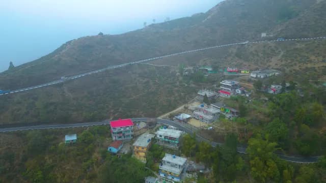 Misty Aerial View of Himalayan Village and Winding Road in Darjeeling