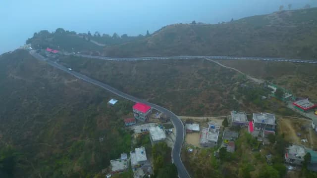 Aerial View of Winding Mountain Road Through Foggy Hillside in Darjeeling