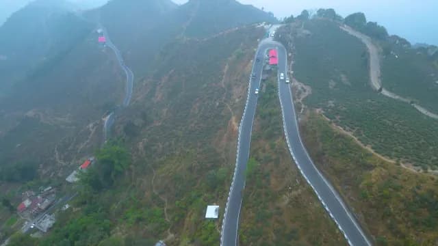Aerial View of Winding Mountain Road through Foggy Tea Plantations in Darjeeling