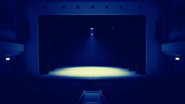 Empty Theater Stage Under Blue Spotlight in Dark Auditorium