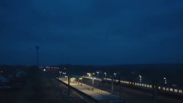 Regional Train Station Platform at Dusk with Passenger Train
