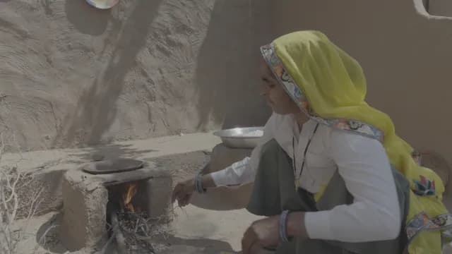 Indian Woman Cooking on Traditional Mud Stove in Rural Rajasthan Village