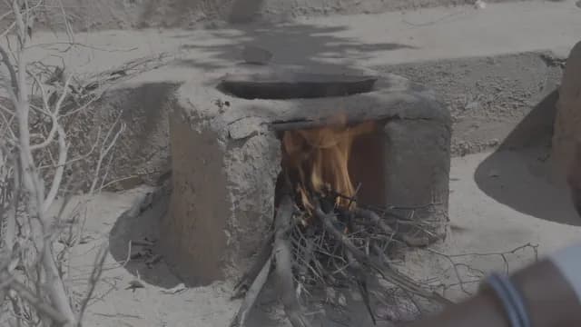 Traditional Mud Stove with Wood Fire for Rural Outdoor Cooking in Rajasthan