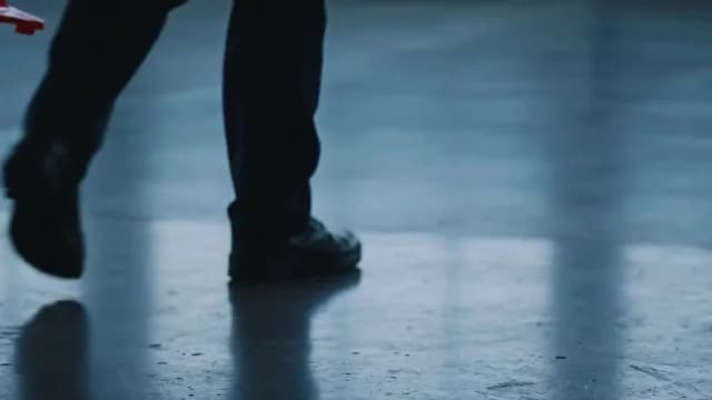 Low Angle Close Up of a Man Keeping a Traffic Cone on Reflective Floor