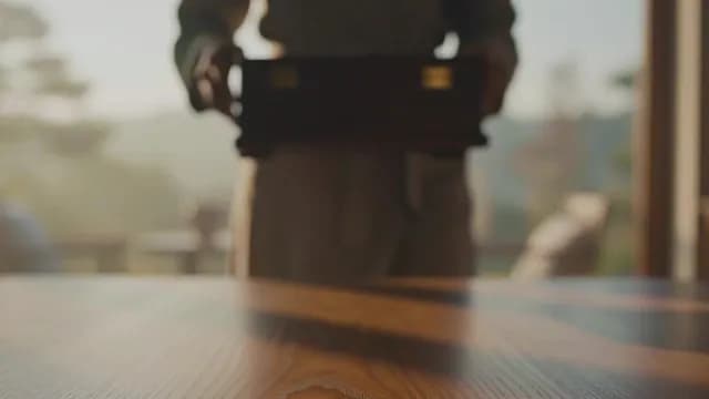 Traditional Japanese Person Holding Wooden Box in Sunlit Room