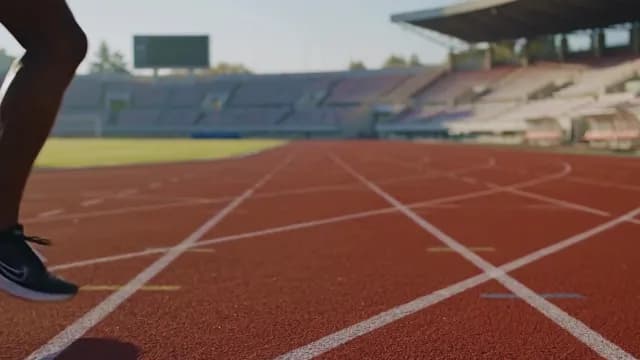 Athlete Sprinting on Red Running Track in Stadium
