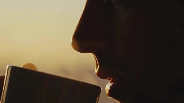 Close Up of Person Drinking Coffee at Sunset