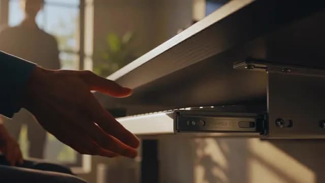 Close-Up of Ergonomic Keyboard Tray Under Desk in Sunlit Office