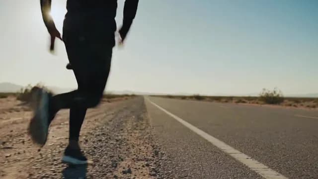 Athletic Man Running Along Empty Desert Highway at Sunset