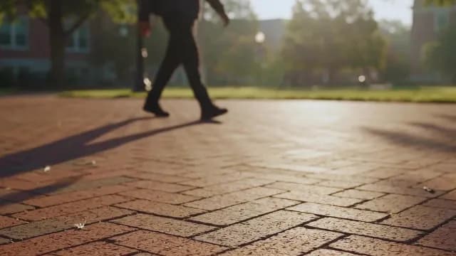 Blurred Student Walking Across Sunny University Campus Courtyard