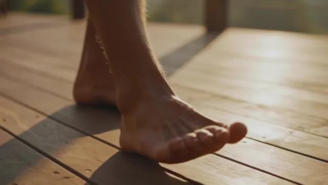 Barefoot Individual Walking on Wooden Deck at Golden Hour