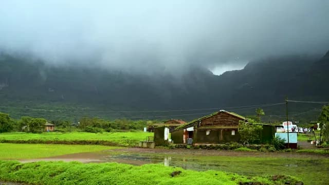 Misty Monsoon Mountains and Rural Village in Green Landscape