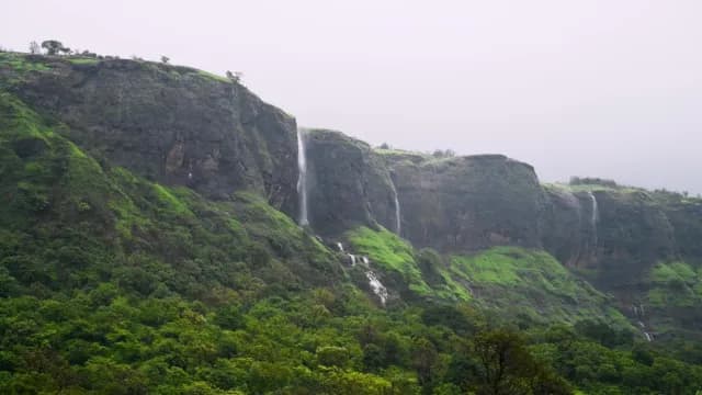 Scenic Waterfalls Cascading Down Lush Green Mountain Cliffs